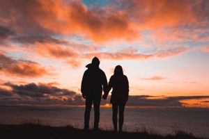 Couple holding hands and looking at horizon