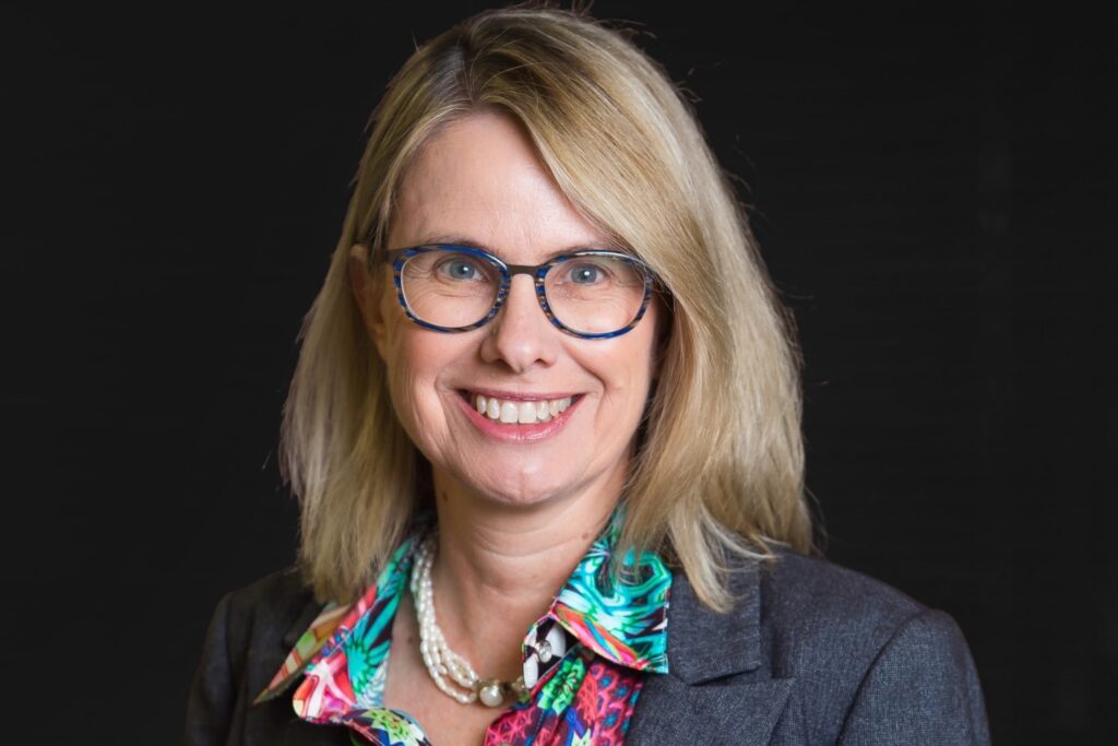 Catherine Cheek|Catherine Cheek and Amanda Schmidt sitting at desk smiling and laughing|Dean Spanner and John Davis sitting at desk smiling|Dean Spanner and Catherine Cheek sitting at desk smiling