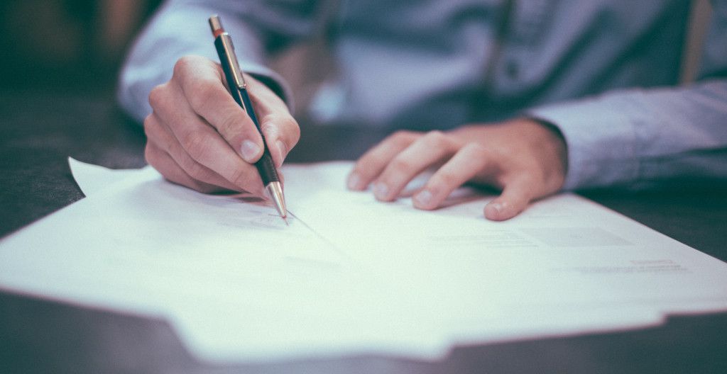 man signing paper
